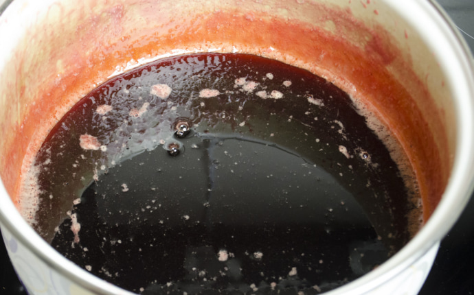 Strawberry jam: Removing the berries from the syrup Strawberry jam: Removing the berries from the syrup