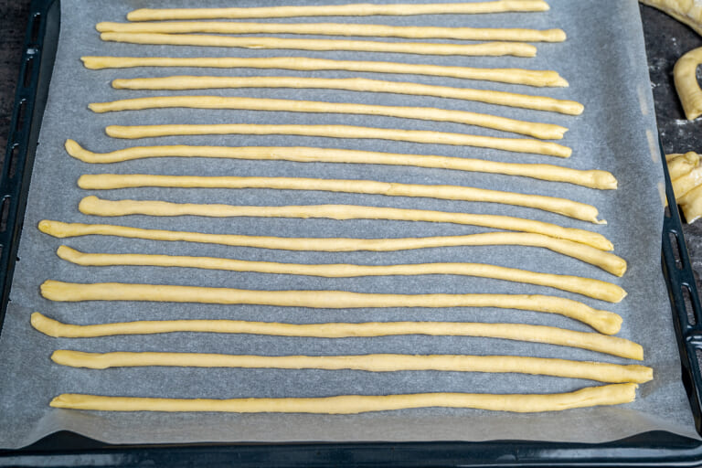 Placing the breadsticks on the baking sheet Placing the breadsticks on the baking sheet