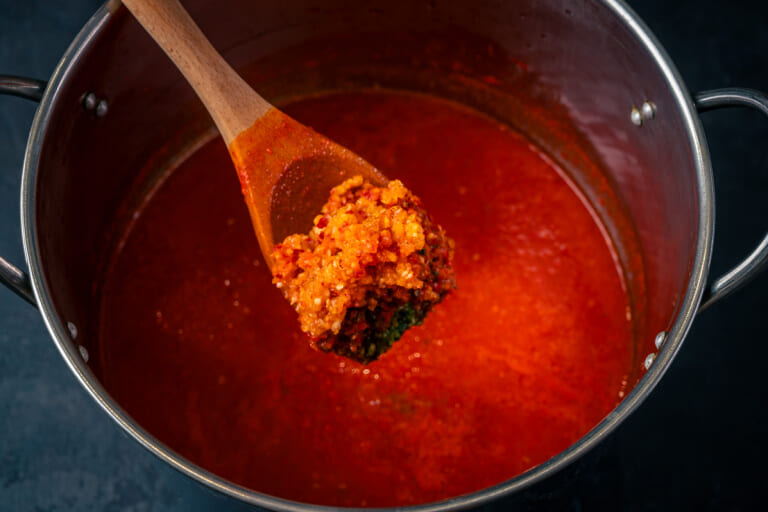 Add minced garlic and chili pepper to the adjika