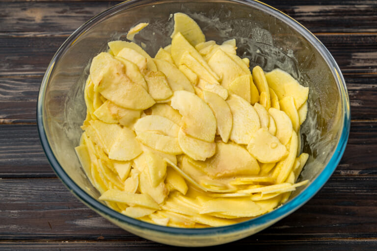Adding apple slices one by one into the batter Adding apple slices one by one into the batter