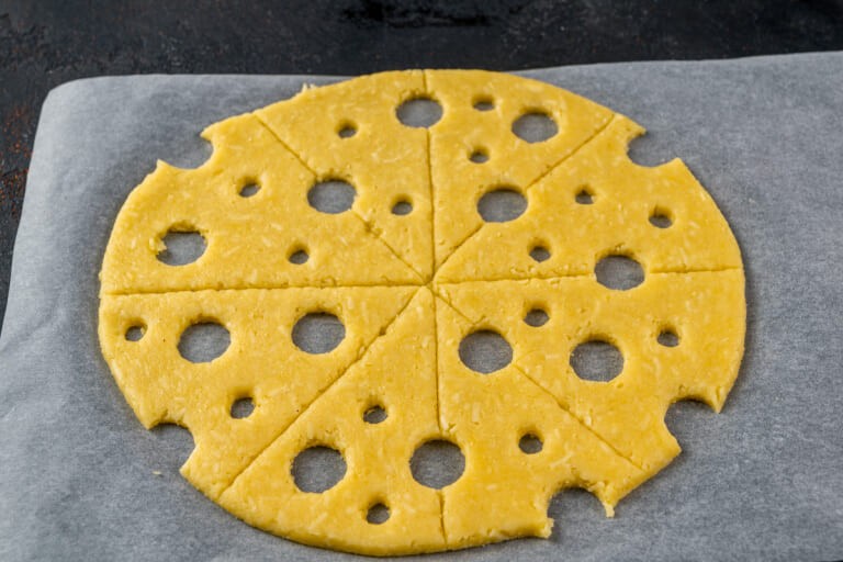 Cut out holes in dough to imitate cheese