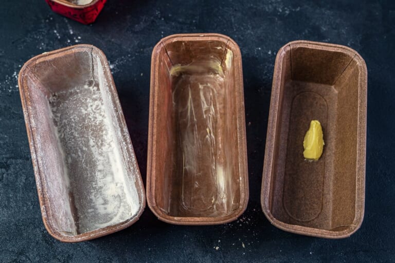 Greasing and flouring the cake pans for baking British Christmas cake