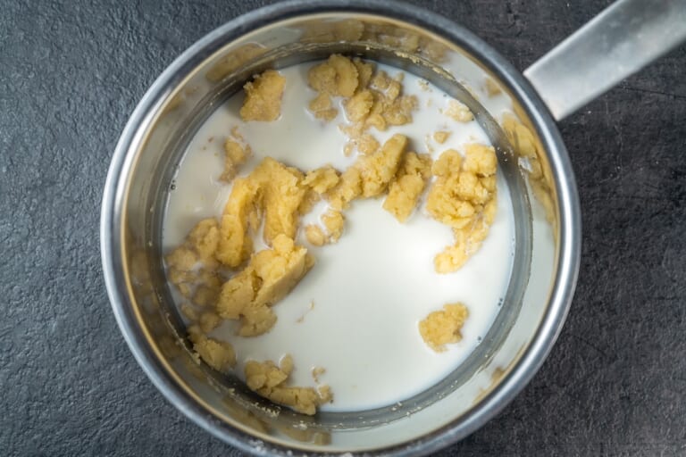 Classic béchamel sauce: adding a portion of hot milk