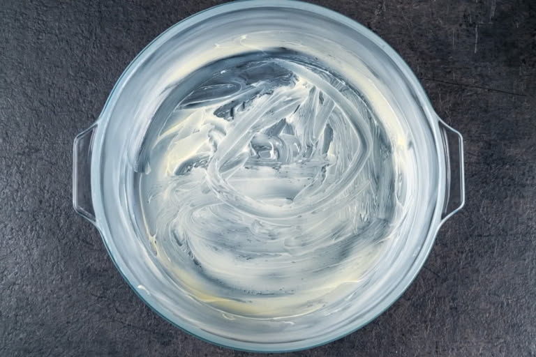 Greasing a round baking dish with butter for the Zapekanka.