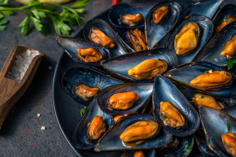 Serving mussels in white wine with lemon and bread. Serving mussels in white wine with lemon and bread.