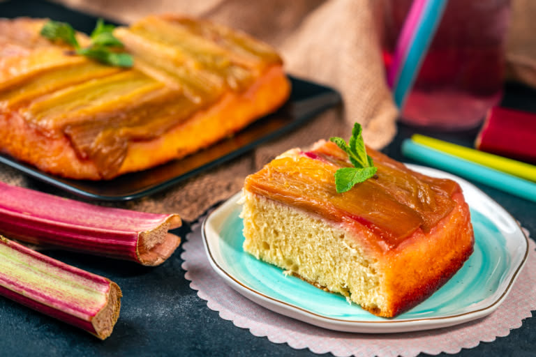 The rhubarb upside-down cake, sliced and ready to be served, decorated with fresh mint