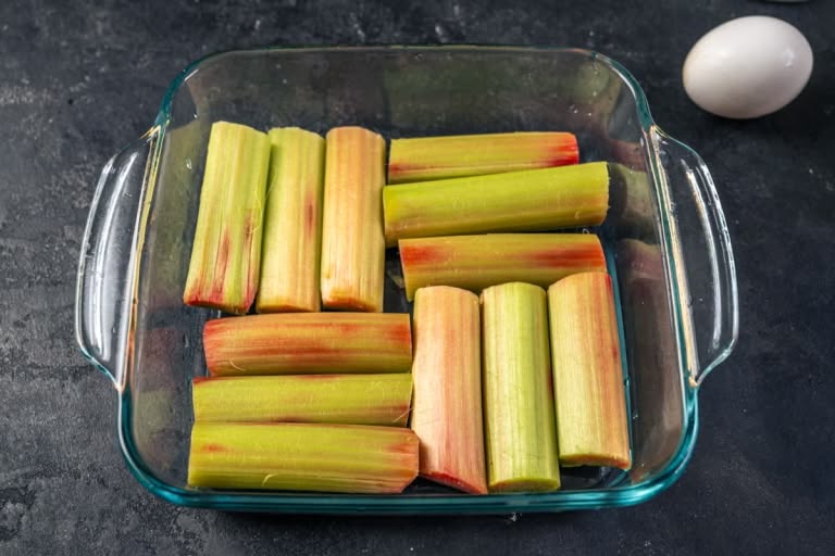Fresh rhubarb stalks being cut into uniform pieces