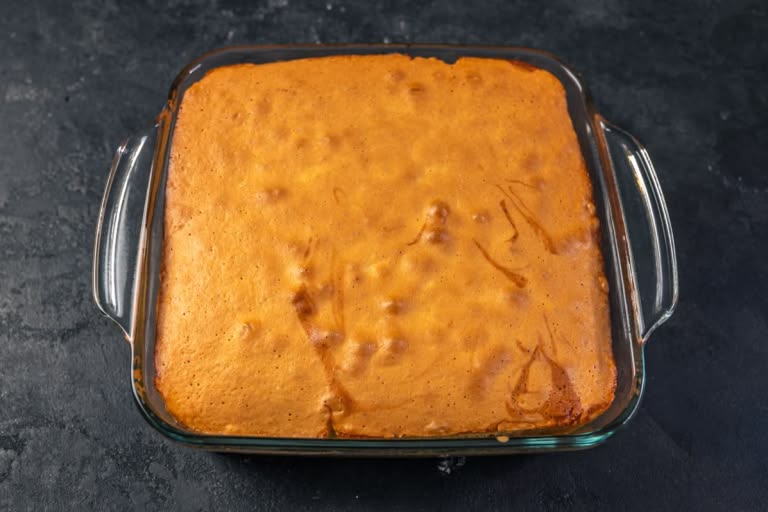 The fully baked rhubarb upside-down cake, golden brown and puffed, just out of the oven.