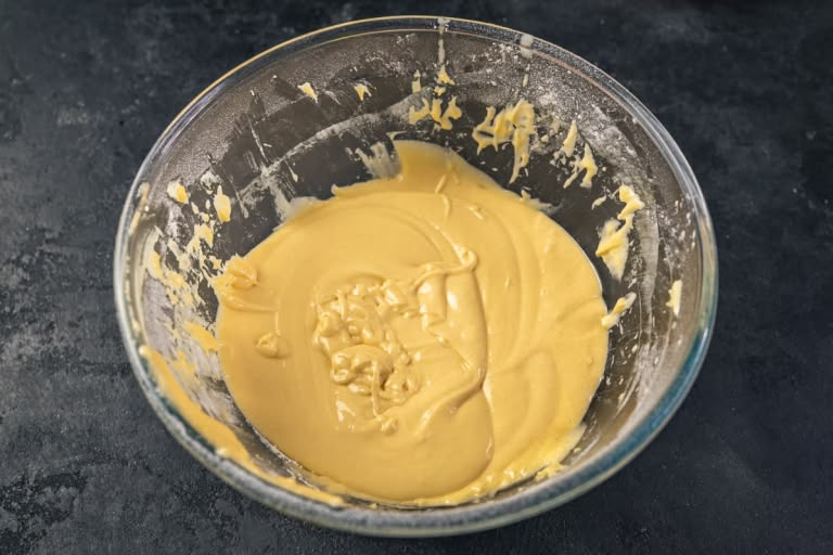 A bowl of smooth, golden cake batter, ready to be poured.