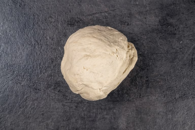 Kneading pelmeni dough on a floured work surface