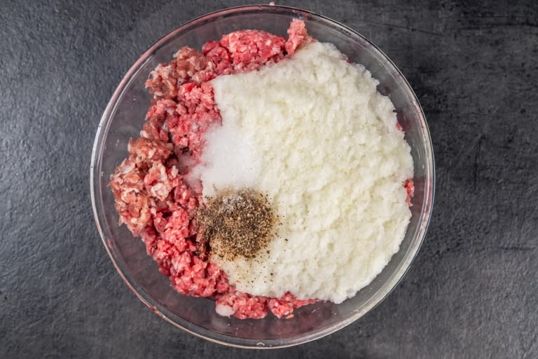 Combining ground beef, pork, and onion for the pelmeni filling