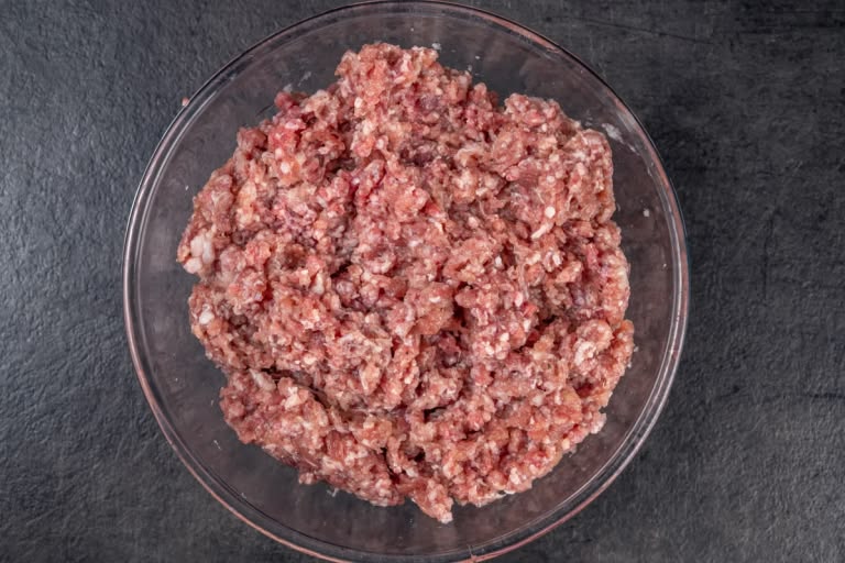 Well-mixed pelmeni meat filling forming a cohesive ball in a bowl
