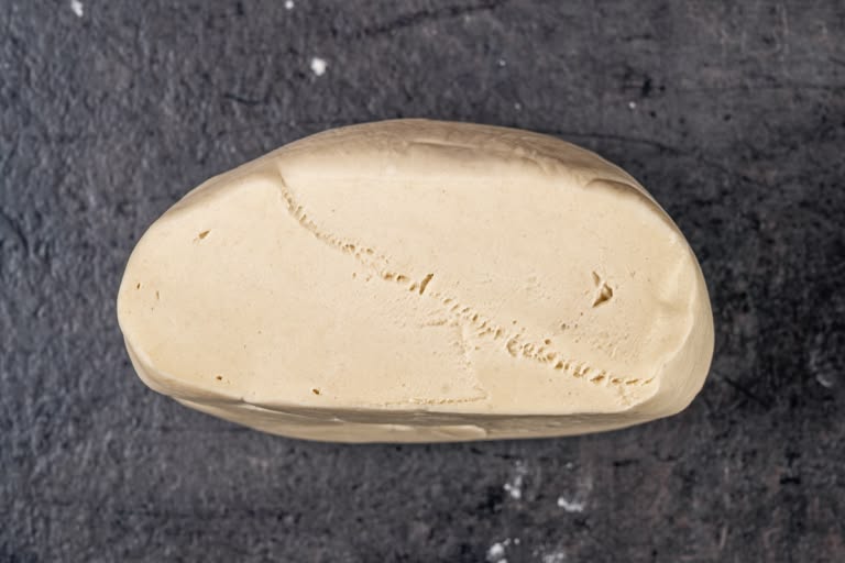 Pelmeni dough divided into four equal pieces before rolling