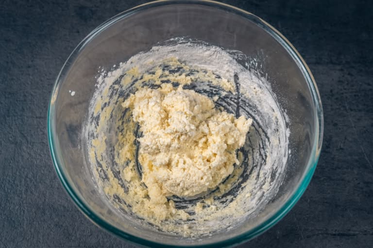 The soft, sticky vareniki dough coming together into a ball in the bowl.