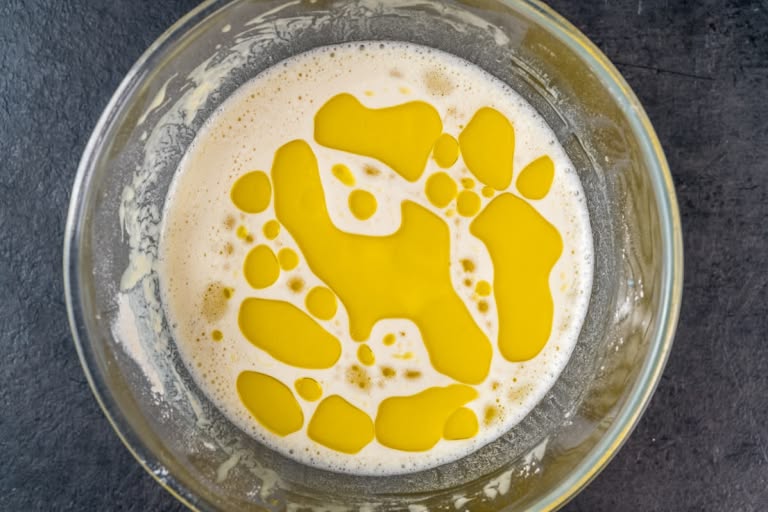 Stirring the remaining milk and vegetable oil into the thin crepe batter